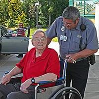 Security employee with patient in wheelchair at 主入口